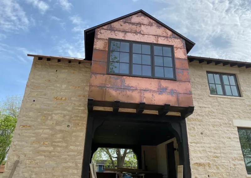 Copper metal panel facade on a stone building for Roof Repair in Highland Park